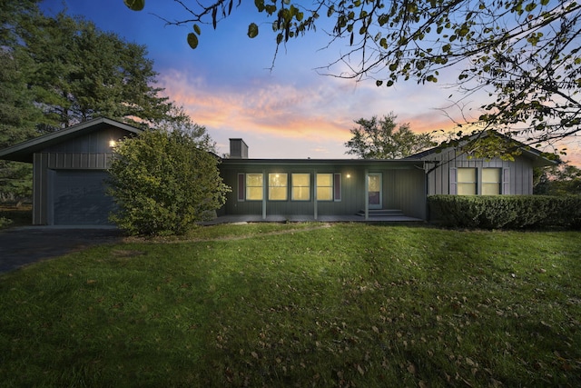 ranch-style home featuring a yard and a garage