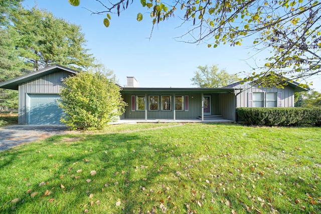 ranch-style house featuring a garage and a front lawn