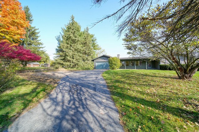 ranch-style house featuring a garage and a front lawn