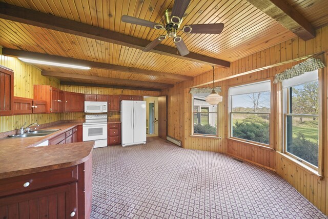 kitchen with a baseboard radiator, sink, pendant lighting, wooden walls, and white appliances