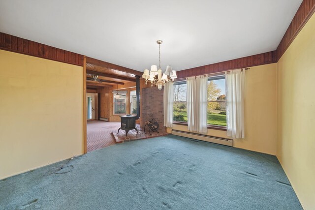 interior space featuring beam ceiling, a wood stove, carpet, a baseboard radiator, and a chandelier