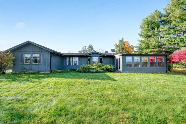 rear view of property with a lawn