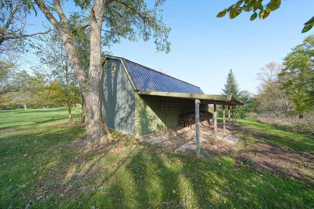 view of home's exterior with a yard and an outbuilding