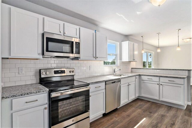 kitchen featuring sink, white cabinets, pendant lighting, and appliances with stainless steel finishes