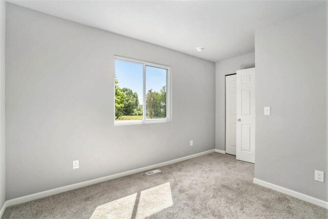 spare room featuring light colored carpet