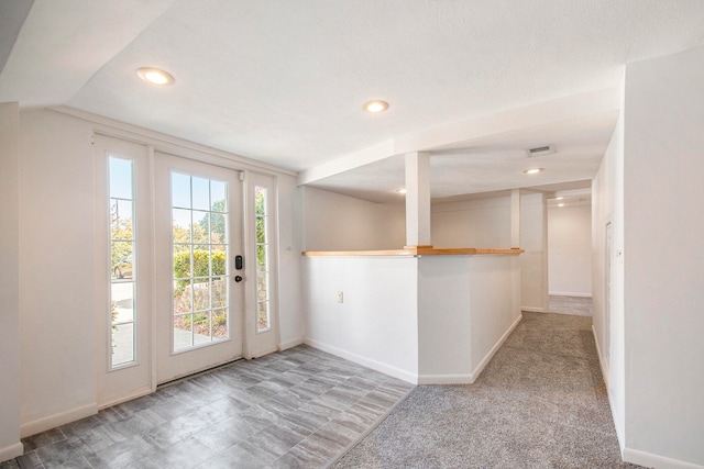 doorway to outside featuring a textured ceiling and carpet floors