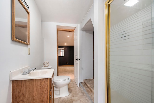 bathroom with a shower with door, vanity, toilet, and tile patterned floors