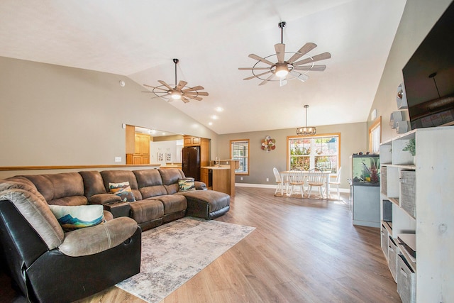 living room featuring lofted ceiling, light wood-type flooring, and ceiling fan