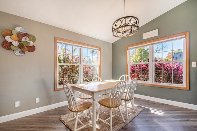 dining space featuring lofted ceiling, a chandelier, and dark hardwood / wood-style floors