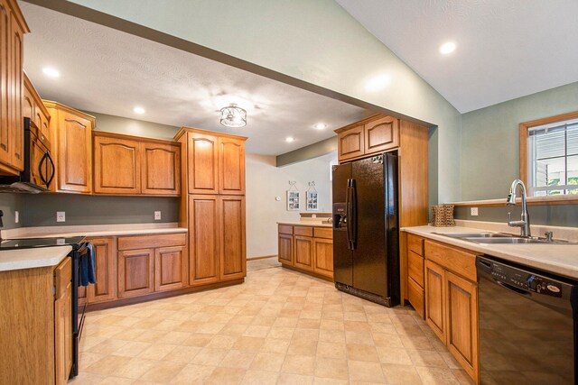 kitchen with a textured ceiling, black appliances, sink, and lofted ceiling