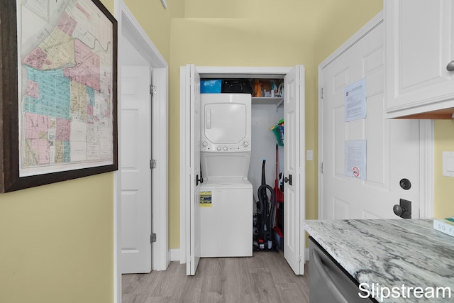 clothes washing area with light wood-type flooring and stacked washer / dryer