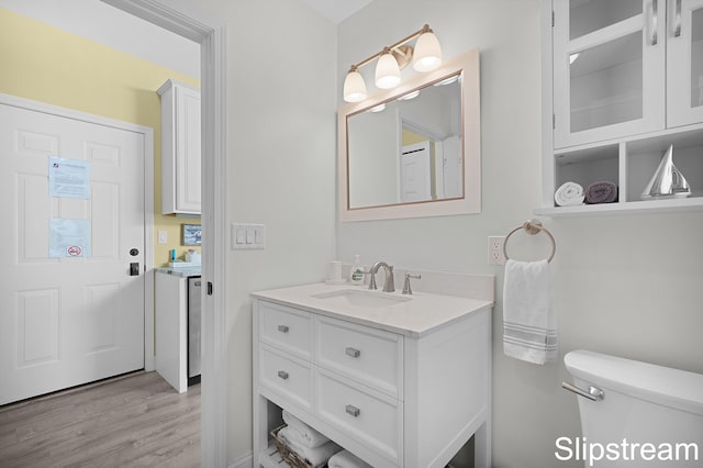 bathroom with vanity, wood-type flooring, and toilet