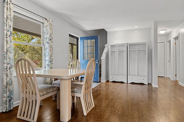 dining space featuring dark wood-type flooring and a textured ceiling