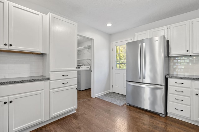 kitchen featuring stainless steel fridge, backsplash, white cabinetry, independent washer and dryer, and dark wood-type flooring