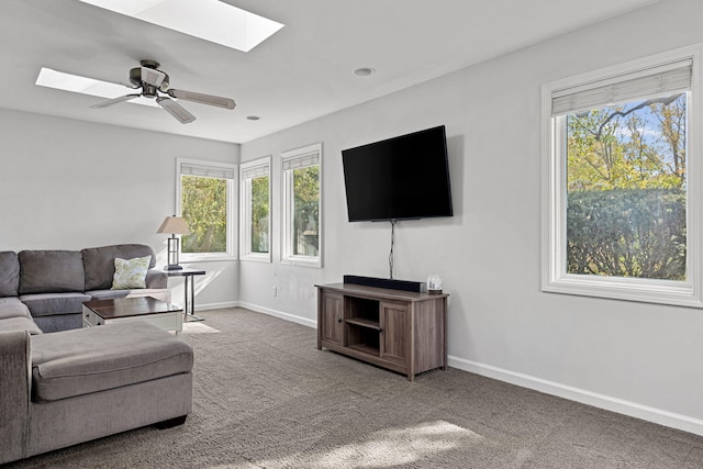 living room featuring carpet floors, ceiling fan, and a wealth of natural light