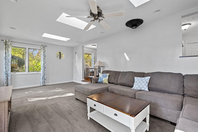 carpeted living room with a skylight and ceiling fan