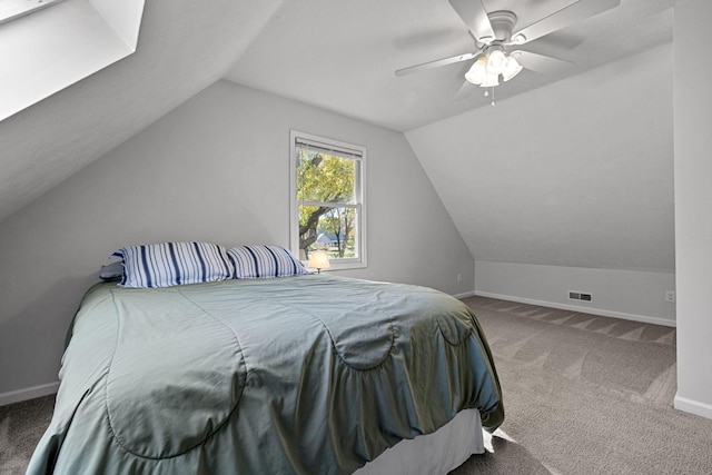 carpeted bedroom with ceiling fan and vaulted ceiling