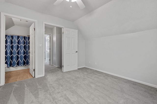 bonus room featuring lofted ceiling, a textured ceiling, carpet, and ceiling fan