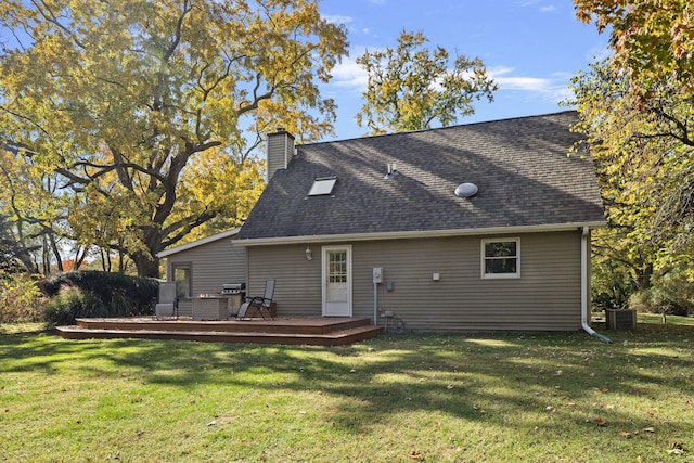 back of property featuring a wooden deck and a lawn