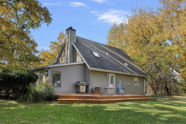 back of property featuring a wooden deck and a lawn