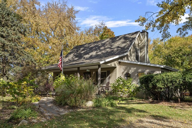 back of house featuring a yard and a porch