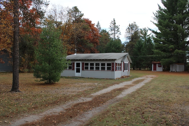 view of front of property featuring a shed