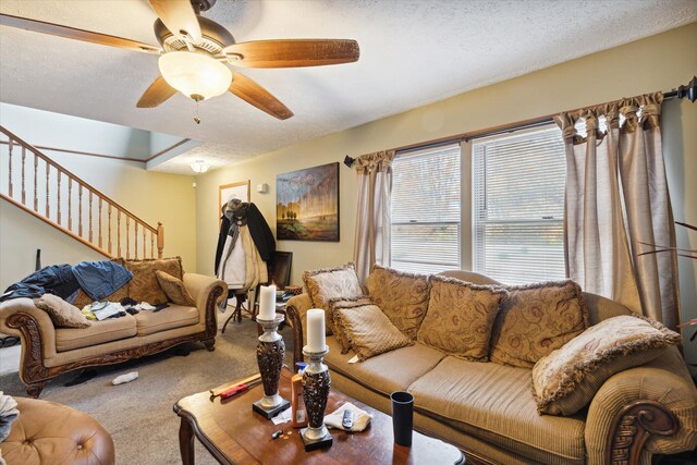 living room featuring ceiling fan, carpet, and a textured ceiling