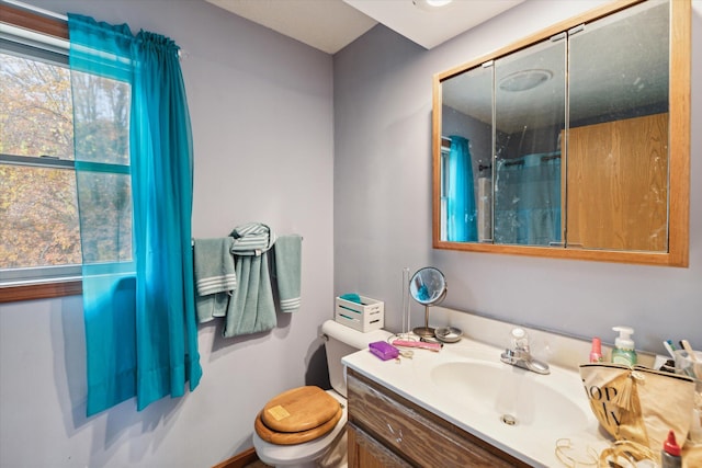 bathroom with vanity, curtained shower, and toilet