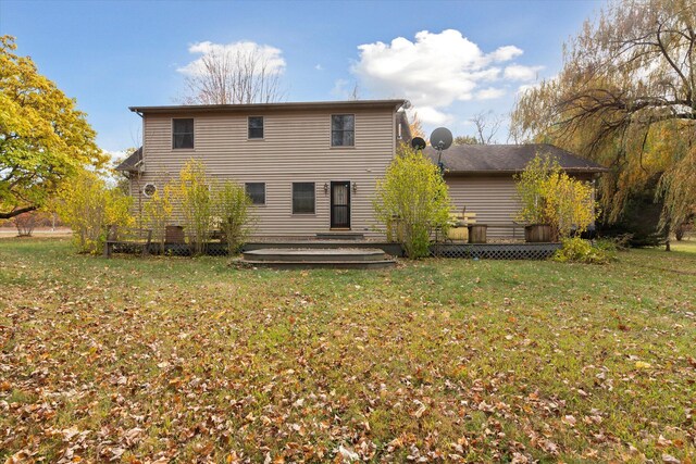 rear view of property featuring a deck and a lawn