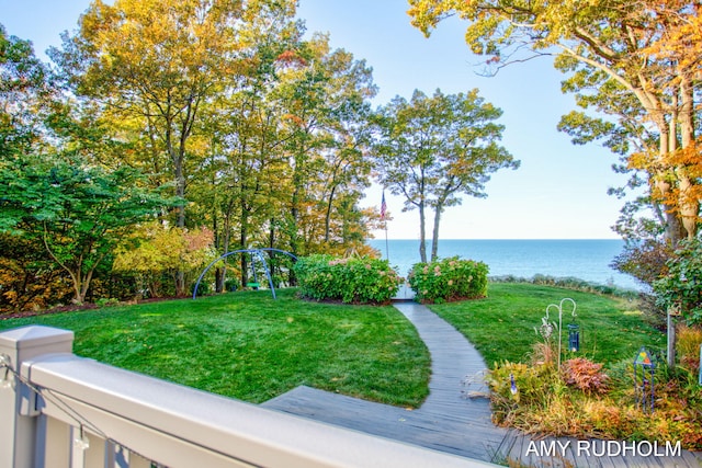 view of property's community with a water view and a lawn