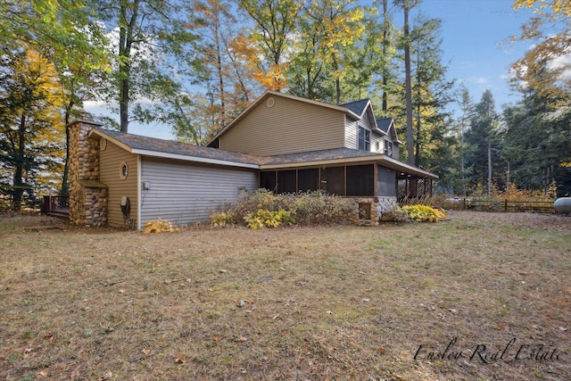 view of home's exterior featuring a sunroom and a lawn