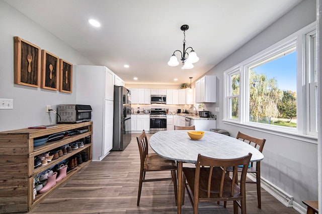 dining room featuring sink, dark hardwood / wood-style flooring, and an inviting chandelier