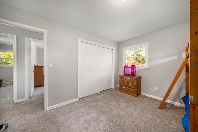 unfurnished bedroom featuring light carpet and a closet