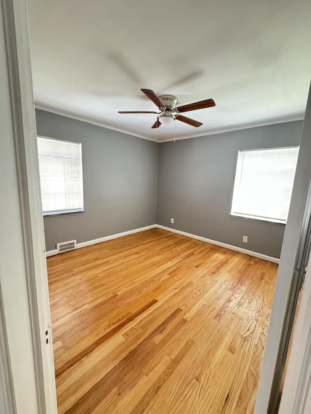 unfurnished room featuring crown molding, light hardwood / wood-style flooring, and ceiling fan