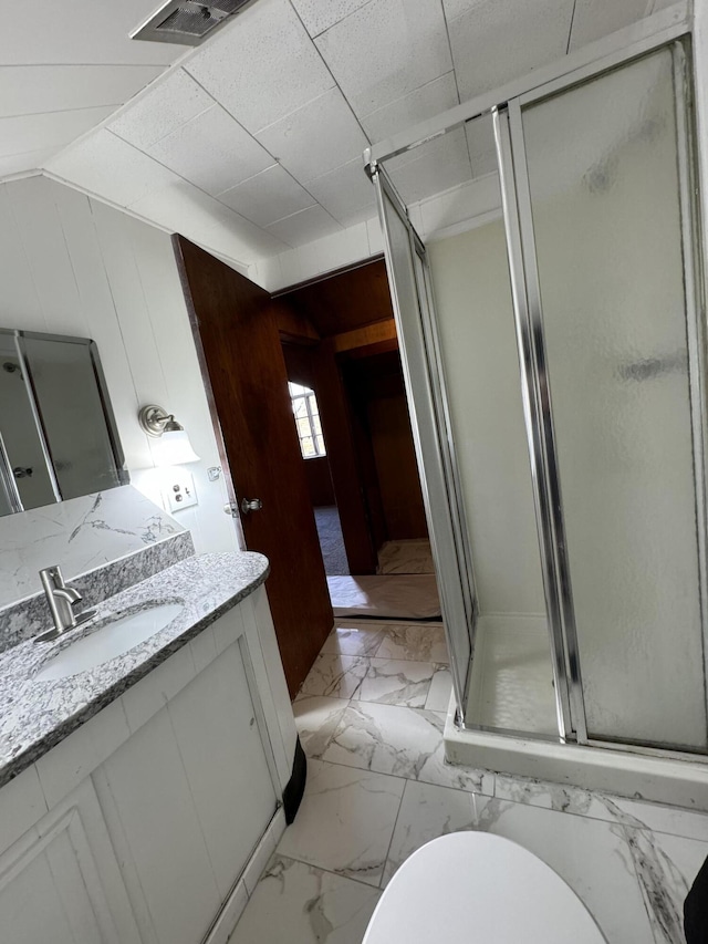 bathroom featuring vanity, an enclosed shower, wood walls, and toilet