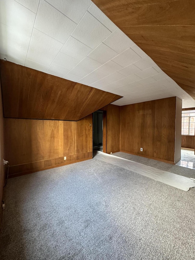 bonus room featuring light carpet, wood walls, vaulted ceiling, and wood ceiling