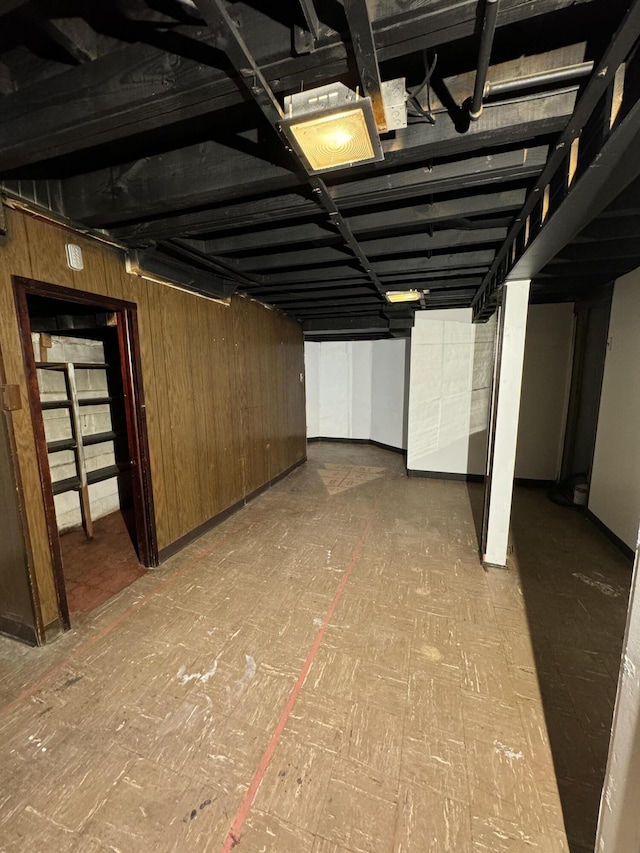 basement featuring wood walls