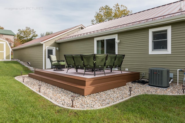 rear view of property with a wooden deck, a shed, a yard, and cooling unit