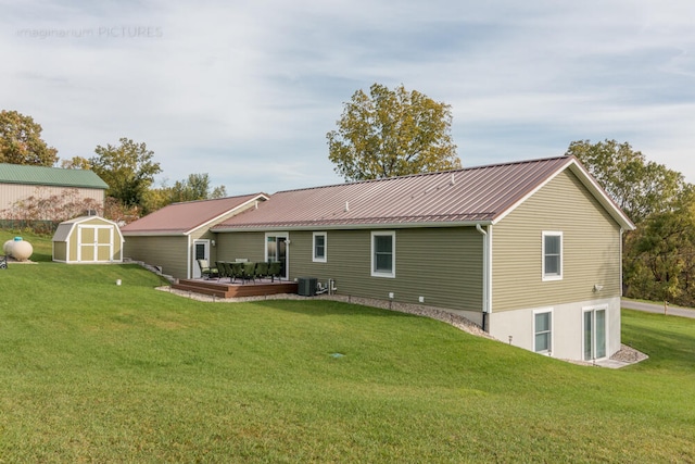 rear view of house with a storage shed, central AC, and a lawn