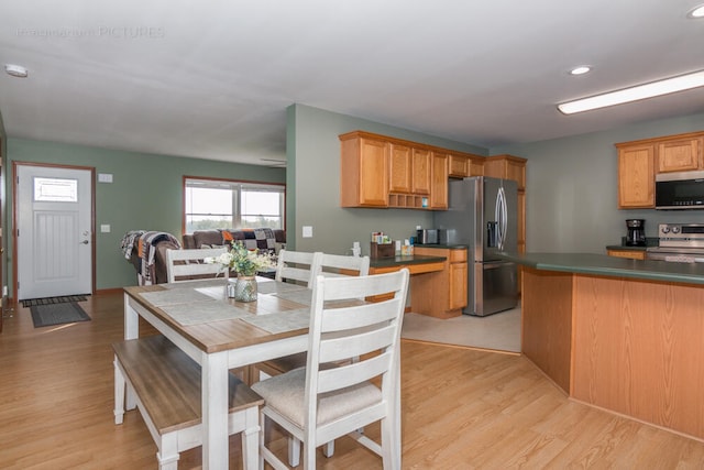 kitchen with appliances with stainless steel finishes and light hardwood / wood-style floors