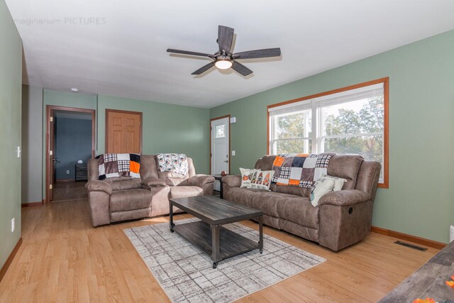 living room featuring ceiling fan and light hardwood / wood-style flooring