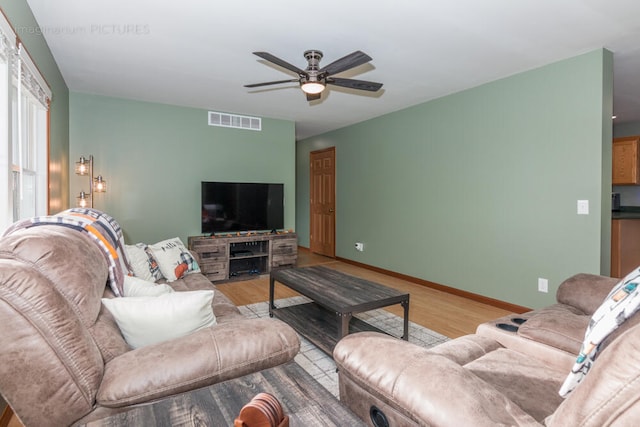 living room with ceiling fan and light wood-type flooring