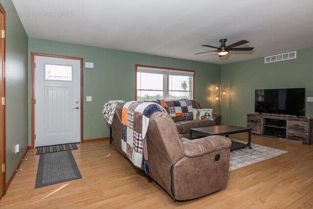 living room featuring light hardwood / wood-style flooring and ceiling fan