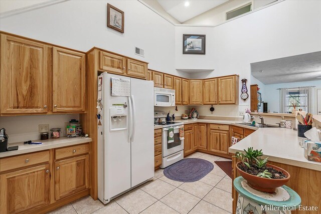 kitchen with white appliances, light tile patterned floors, high vaulted ceiling, sink, and kitchen peninsula