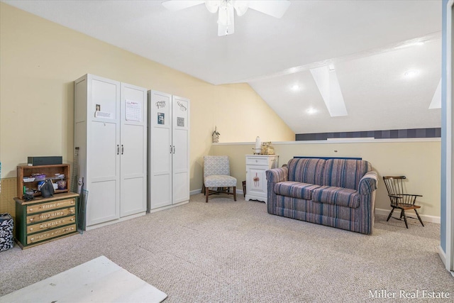 sitting room featuring light carpet, ceiling fan, and vaulted ceiling with skylight