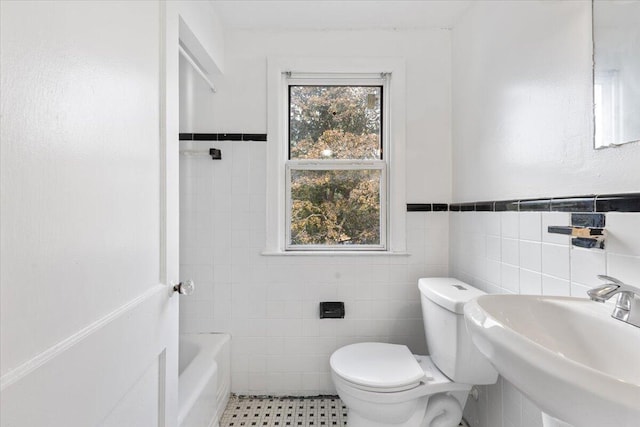 bathroom with sink, a washtub, toilet, tile walls, and tile patterned flooring