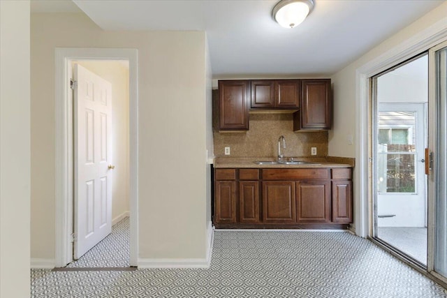 kitchen with sink, dark brown cabinets, and backsplash