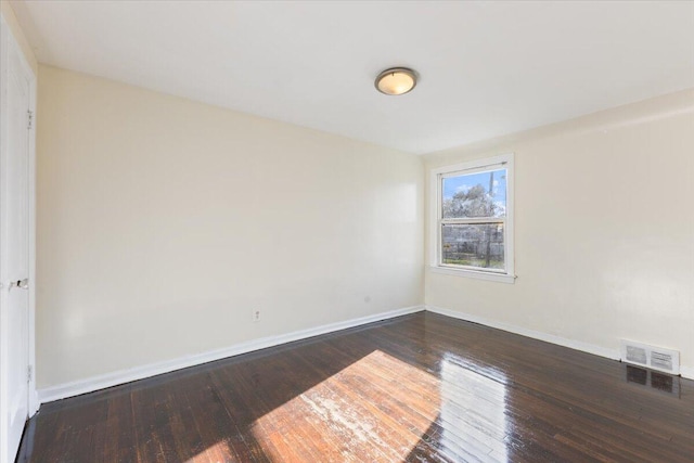 spare room with dark wood-type flooring