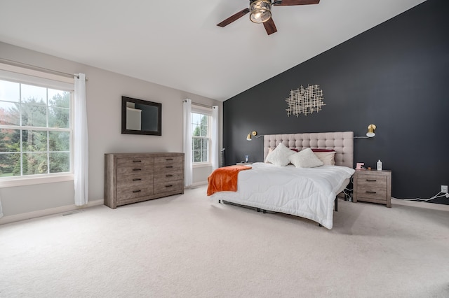 carpeted bedroom with ceiling fan and high vaulted ceiling