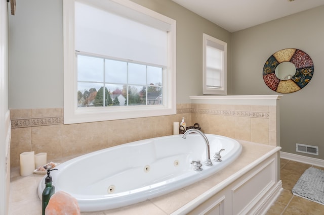 bathroom with tile patterned floors and tiled tub